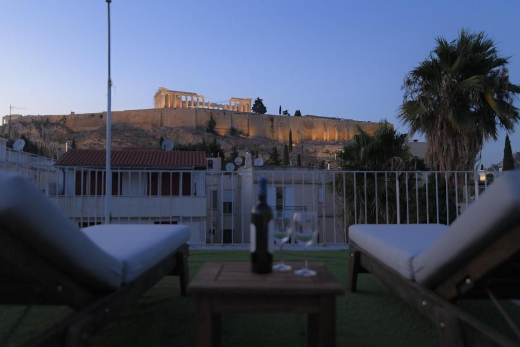 a balcony with two chairs and a table with a building at Acropolis Hill House in Athens