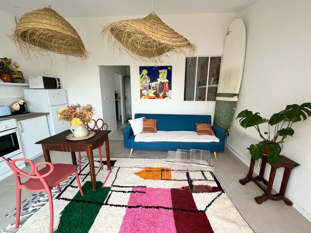 un salon avec un canapé bleu et une table dans l'établissement Maison 60 m plage, à Saint-Hilaire-de-Riez