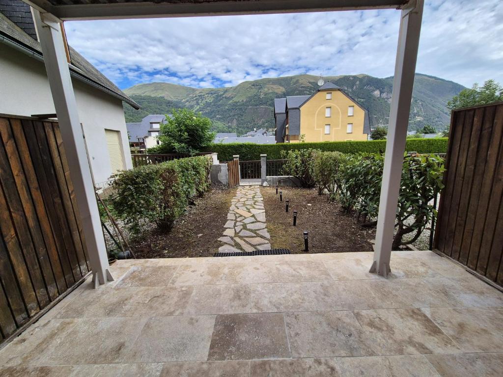 Elle offre une vue sur une terrasse avec une maison et des montagnes. dans l'établissement Appartement Saint Lary Soulan centre-ville, à Saint-Lary-Soulan