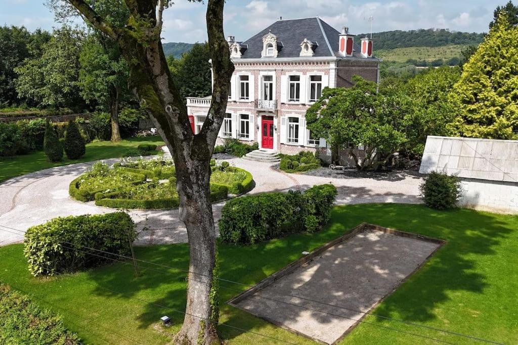 a large white house with a red door at Manoir aux roses, gîte 15 personnes avec Spa in Bonningues-lès-Ardres