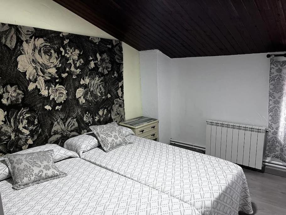 a bedroom with a bed with a floral wallpaper at La Cariochaca in Casas Ibáñez