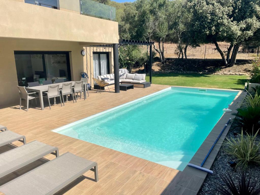 - une piscine dans une cour avec des chaises et une table dans l'établissement Casa olival, à Oletta