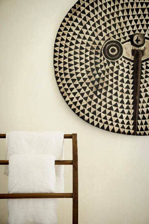 a mirror hanging on a wall next to a chair at Qambani Luxury Resort in Michamvi