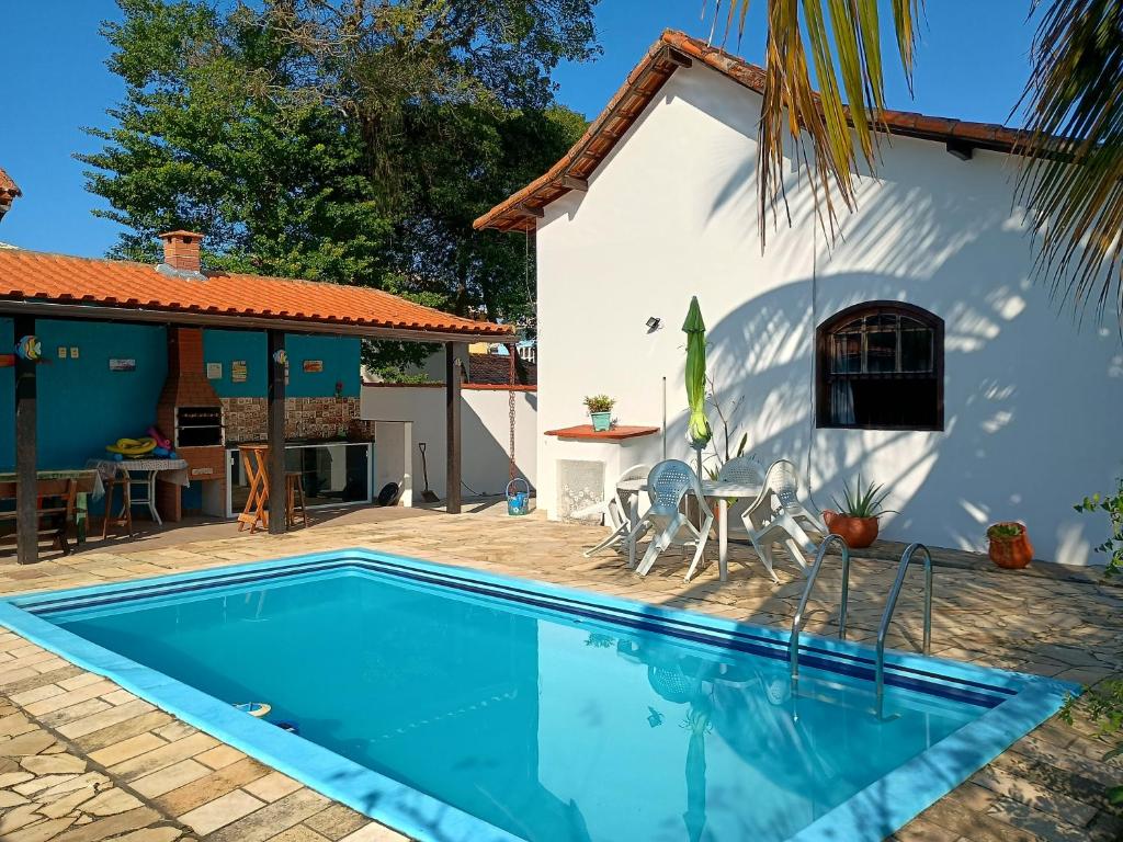 a villa with a swimming pool in front of a house at Casa do Sol, luz e Vida. in Saquarema