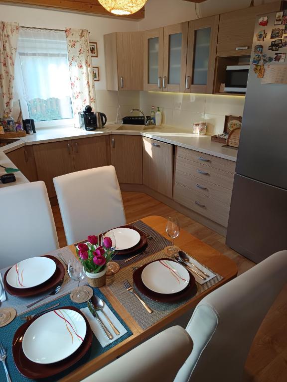 a kitchen with a table with plates and wine glasses at Bungalov Jozef in Liptovská Teplička
