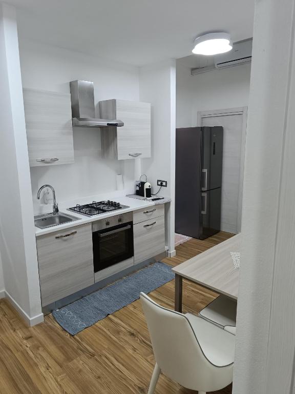 a kitchen with a stove and a sink and a table at Colombo House in Quartu SantʼElena