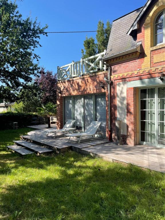 une maison avec une terrasse munie de chaises dans l'établissement Maison acces plage, à Trouville-sur-Mer