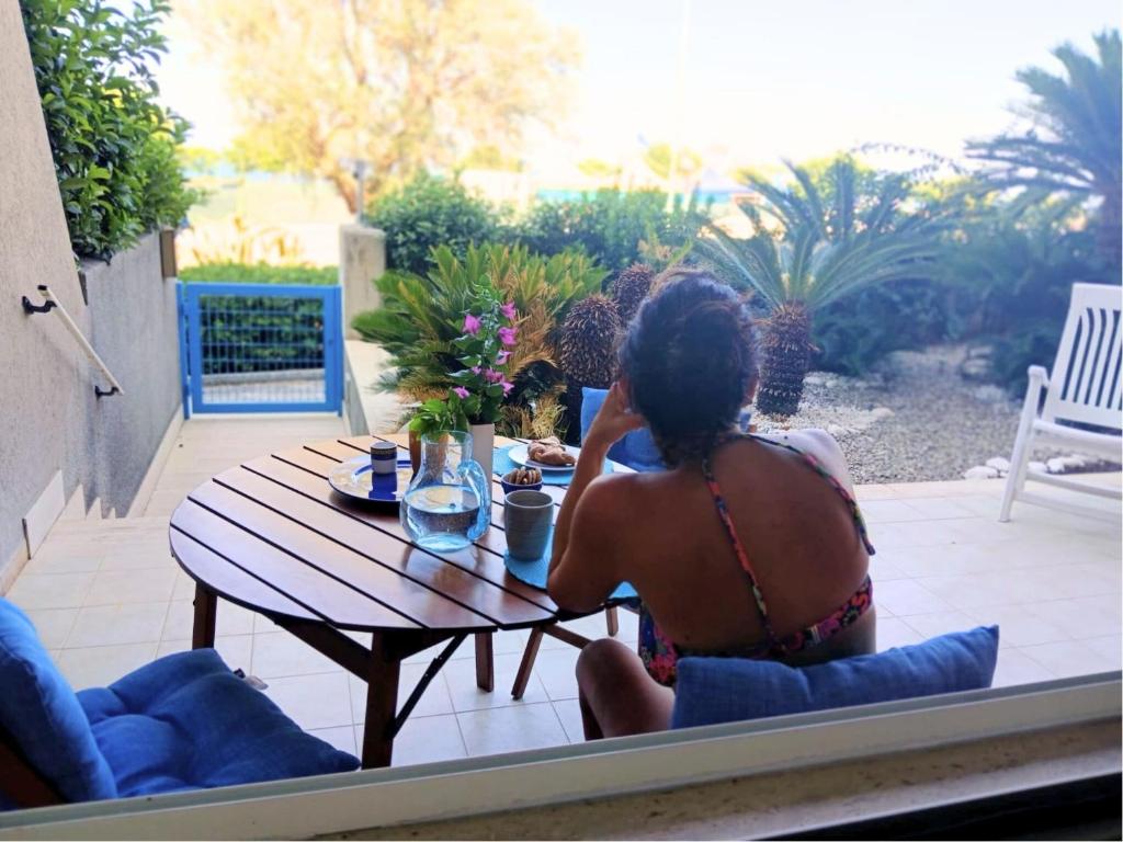una mujer en bikini sentada en una mesa en Casa Dormio, en Monopoli