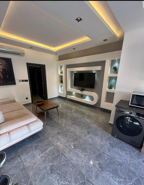 a living room with a couch and a flat screen tv at BLU Apartments Sébénicoro in Bamako