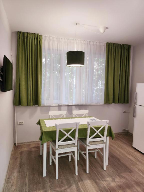 a kitchen with a table and two chairs and a refrigerator at Апартамент Квадратчето in Vratsa
