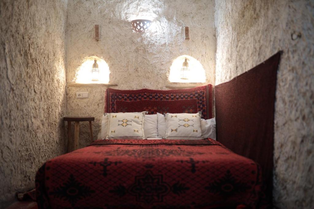 ein Schlafzimmer mit einem roten Bett mit zwei Fenstern in der Unterkunft Traditional house in Marrakesch