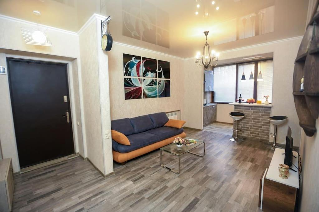 a living room with a blue couch and a kitchen at Agmashenebeli Lilu's Apartment 2 in Tbilisi City