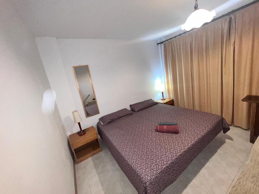 ein Schlafzimmer mit einem Bett mit einer roten Tasche darauf in der Unterkunft Habitación en Manacor in Manacor