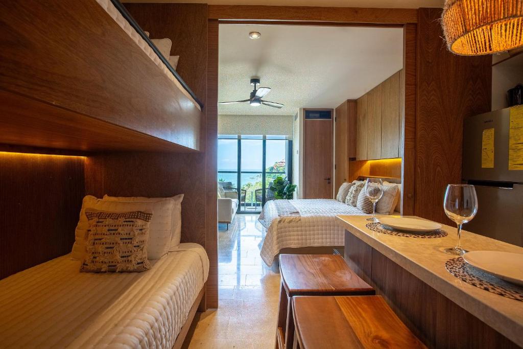 a hotel room with two beds and a wine glass at Beachfront|Pool|Gym Beautiful Studio Zantamar 303D in Cruz de Huanacaxtle