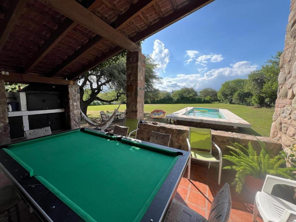 a pool table on a patio next to a swimming pool at Quinta Lo de Dito in Villa Allende