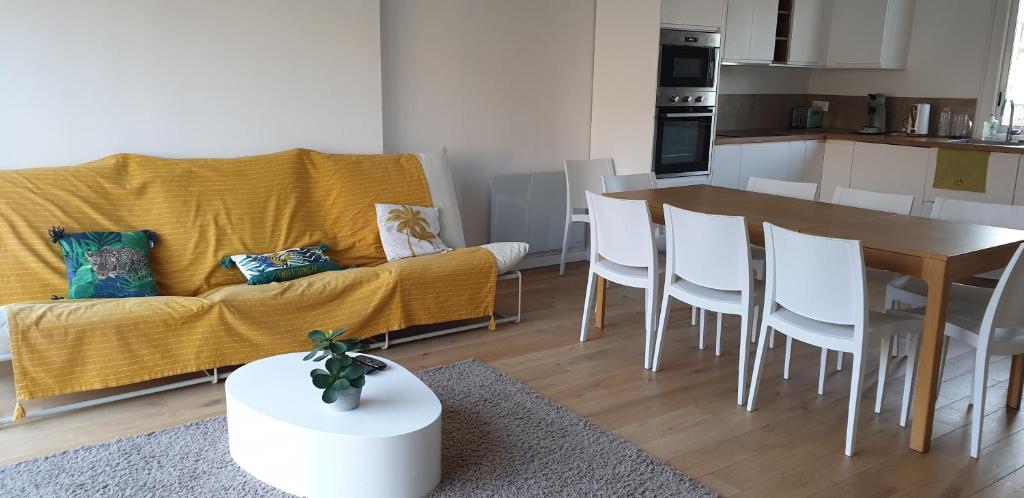 un salon avec un canapé, une table et des chaises dans l'établissement jolie maison de village avec jardin, à Saint-Mandrier-sur-Mer