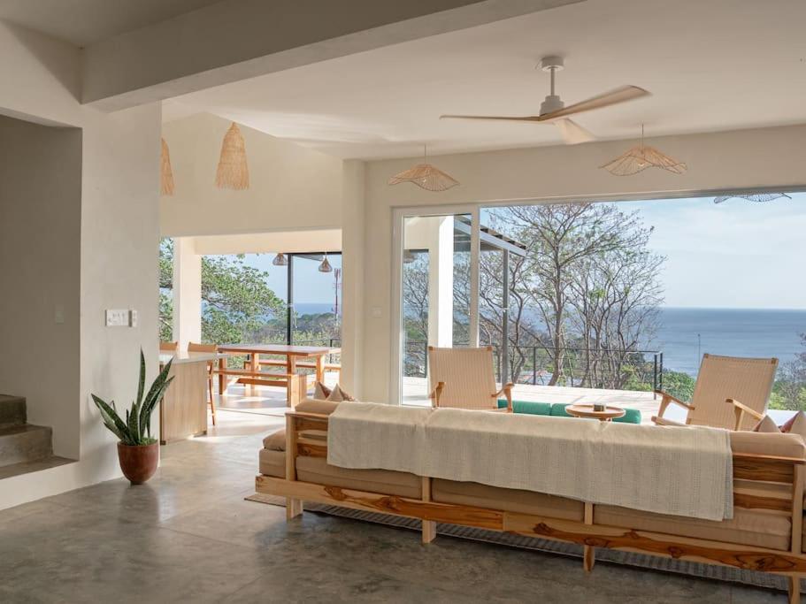 a bedroom with a bed and a view of the ocean at Casa Deriva - Modern 3 Bedroom AC with Pool in Playa Maderas