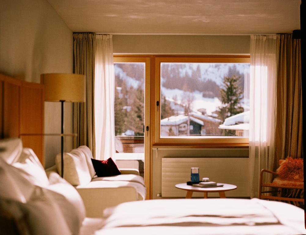 a hotel room with a bed and a window with a view at Hotel Schwarzwand in Lech am Arlberg