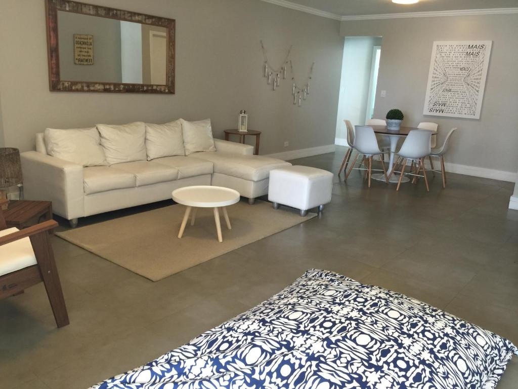 a living room with a couch and a table at Apartamento Vereda Tropical in Guarujá