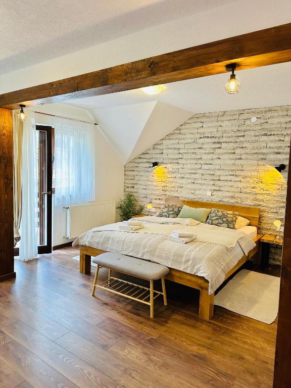 普利特维采村B&B Villa Plitvica的一间带大床和砖墙的卧室