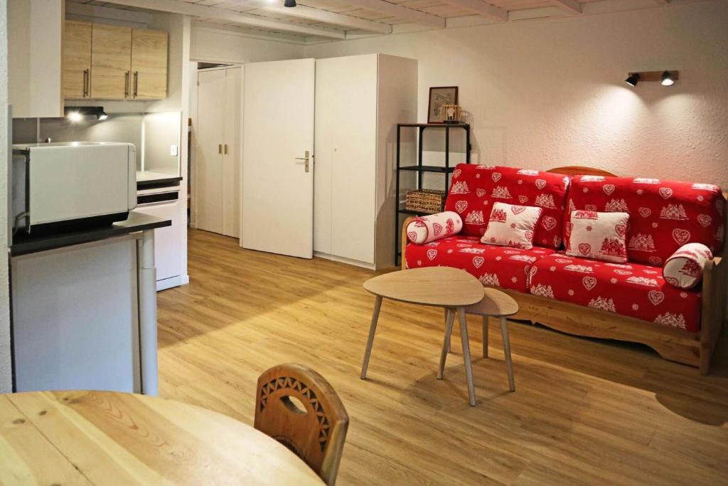 un salon avec un canapé rouge et une table dans l'établissement Résidence Le Silhourais - Très joli Studio 4 personnes idéal pour famille MAE-9331, aux Orres