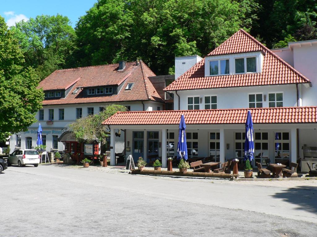 un edificio con sombrillas azules al lado de una calle en Schaumburger Ritter en Schaumburg