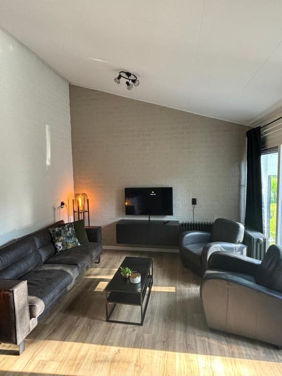 Una sala de estar con un sofá y un televisor. en Casa 3, en Simpelveld