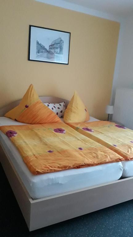 a bedroom with two beds with orange sheets and an airplane on the wall at Ferienwohnung Alte Mühle in Stolberg i. Harz