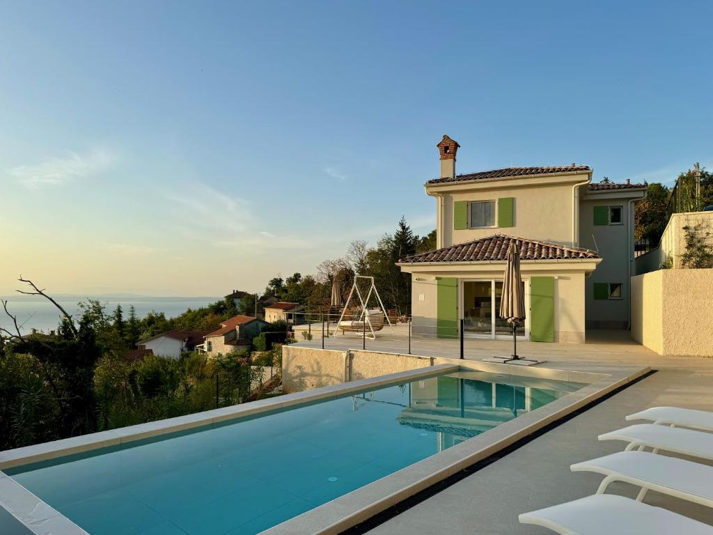 a swimming pool in front of a house at Villa Lula, Pool, Sauna, 6 Personen, 3 Bäder in Dobreć