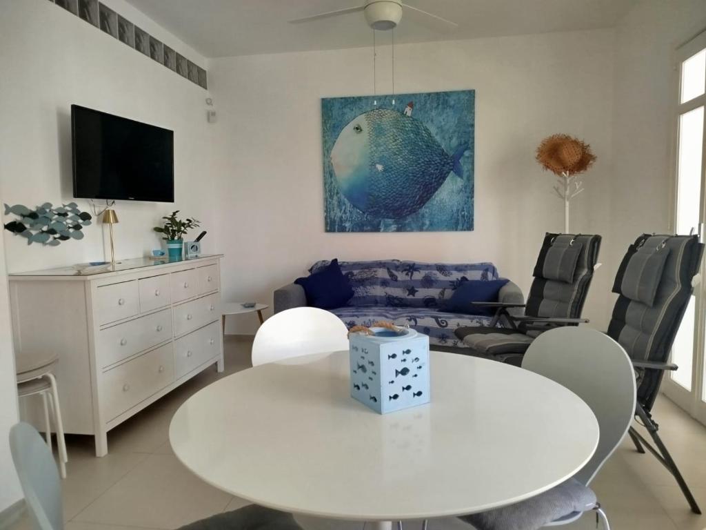 een woonkamer met een witte tafel en een bank bij Casa Vacanze Pesce Palla in Villaggio Azzurro