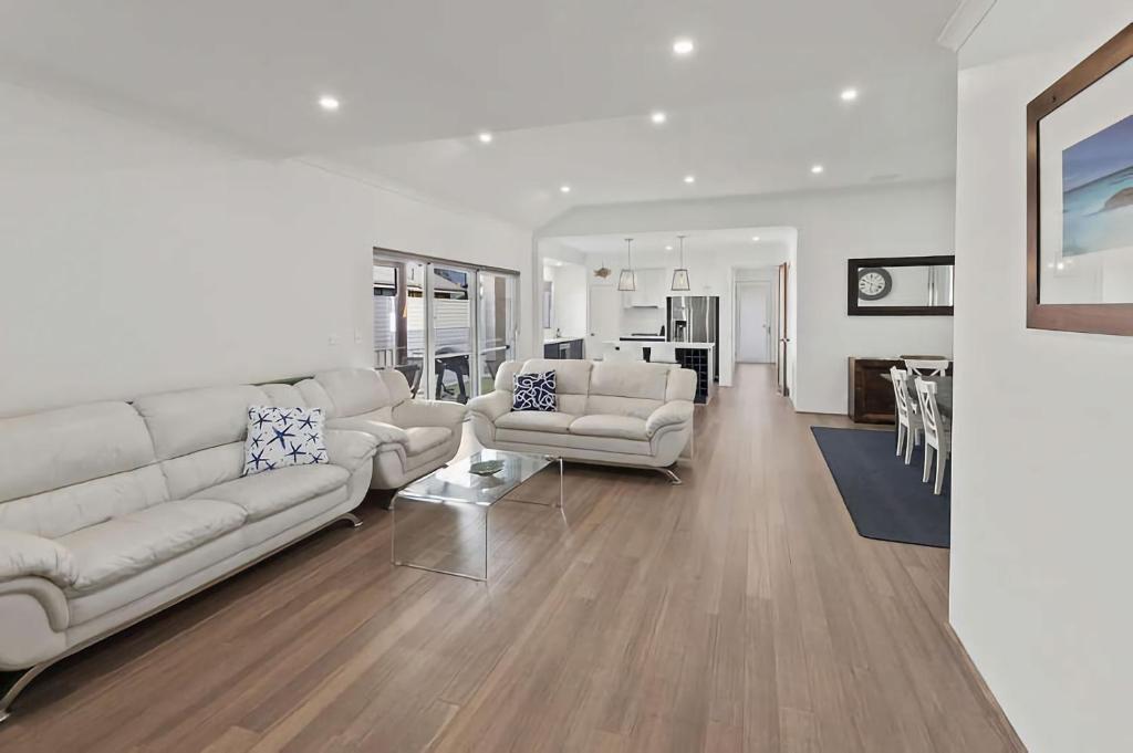 a living room with white furniture and a dining room at Vasse Manor in Vasse