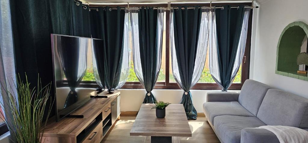 ein Wohnzimmer mit Couch und großem Fenster in der Unterkunft Appartement de 65m2 avec piscine partagée in Tremblay En France