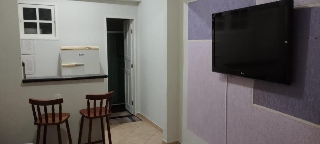 un soggiorno con due sedie e una TV a schermo piatto su una parete di Sea Like 2 - Casa para temporada ad Arraial do Cabo