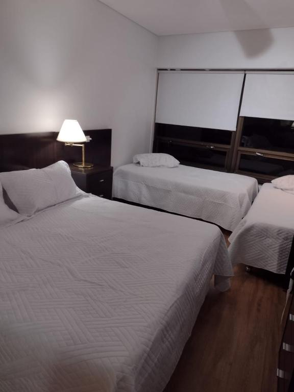 a hotel room with two beds and a lamp at Apart Bayres Obelisco in Buenos Aires