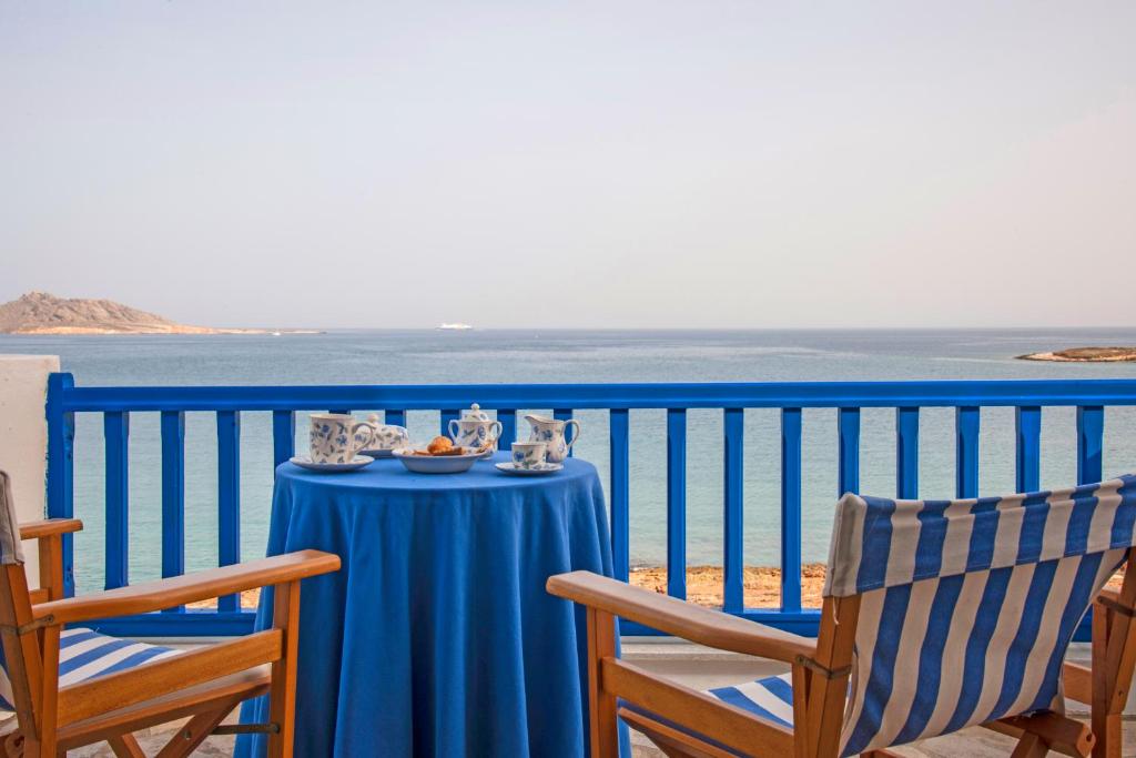 einen blauen Tisch und Stühle auf einem Balkon mit Meerblick in der Unterkunft Sea Front Villa in Naoussa