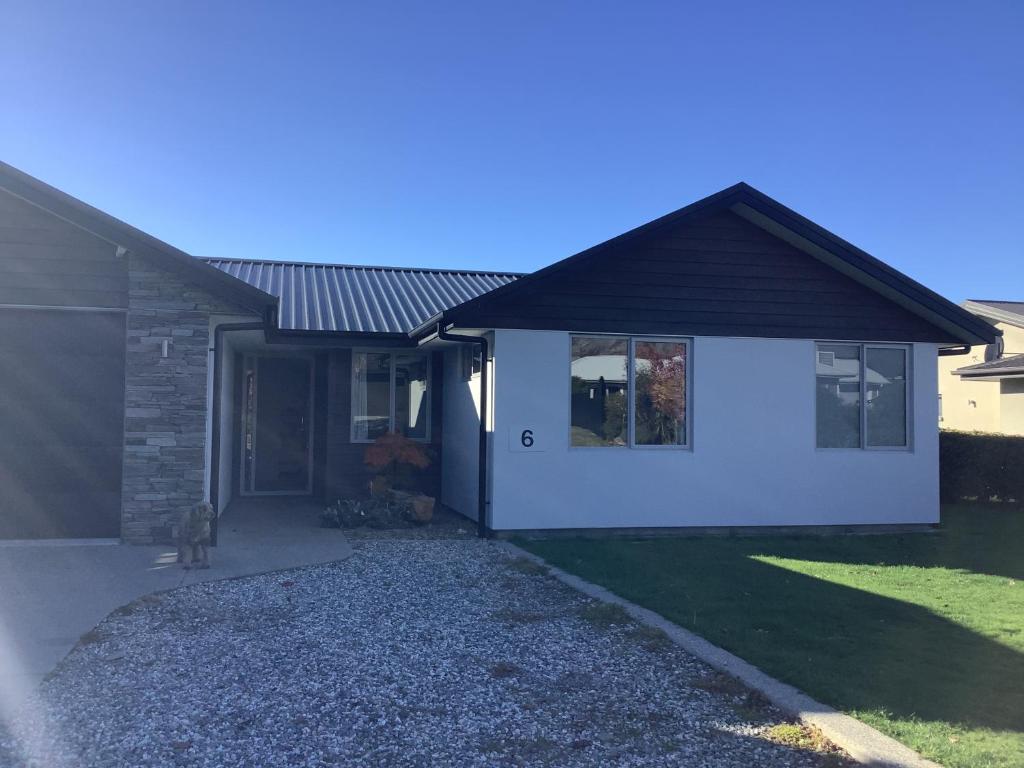una casa con un gato sentado frente a ella en Wanaka Holiday, en Wanaka