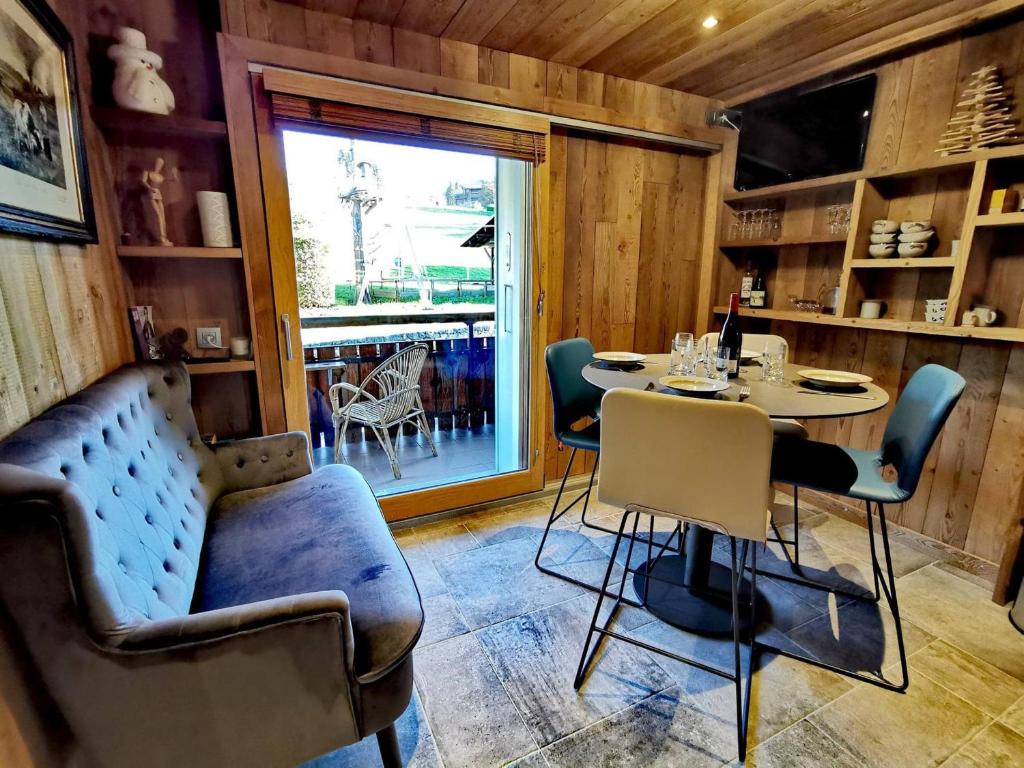une salle à manger avec une table et des chaises et une fenêtre dans l'établissement Superbe studio rénové style montagne, pied des pistes, 4 pers. Ski locker, ménage inclus - FR-1-598-134, aux Gets