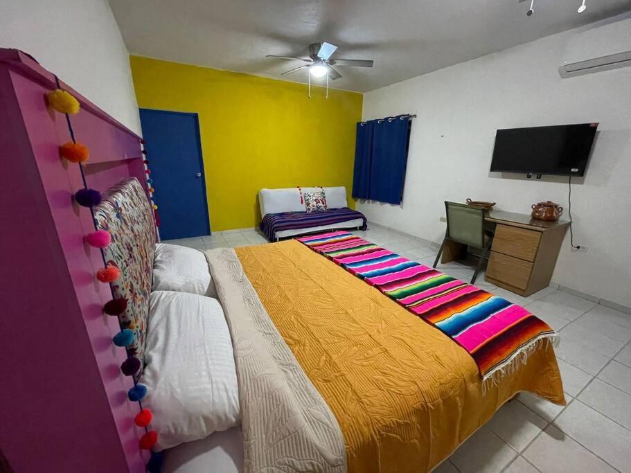 a bedroom with a bed and a tv in it at Casa Alebrijes in La Paz