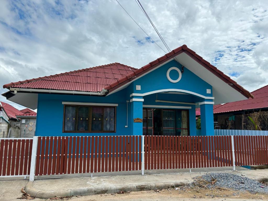 een blauw huis met een rood hek ervoor bij Entire Home with King Bed in Chiang Mai