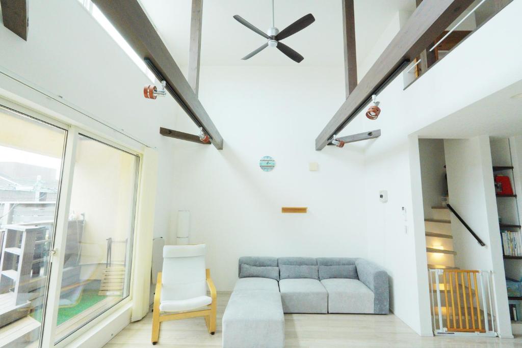 a living room with a couch and a chair at Chigasaki Southern Beach House 茅ヶ崎サザンビーチハウス in Chigasaki
