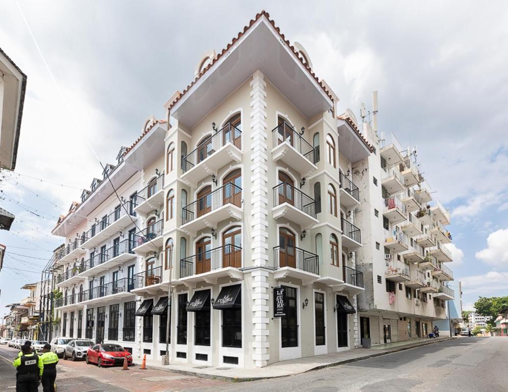 un grande edificio bianco all'angolo di una strada di La Cuadra Apartments By Acomodo a Città di Panama