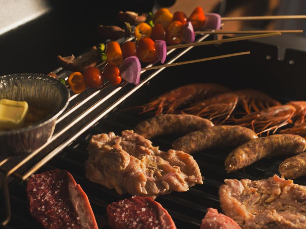 a grill with meats and other foods on it at Seage Torami Coastside in Ichinomiya