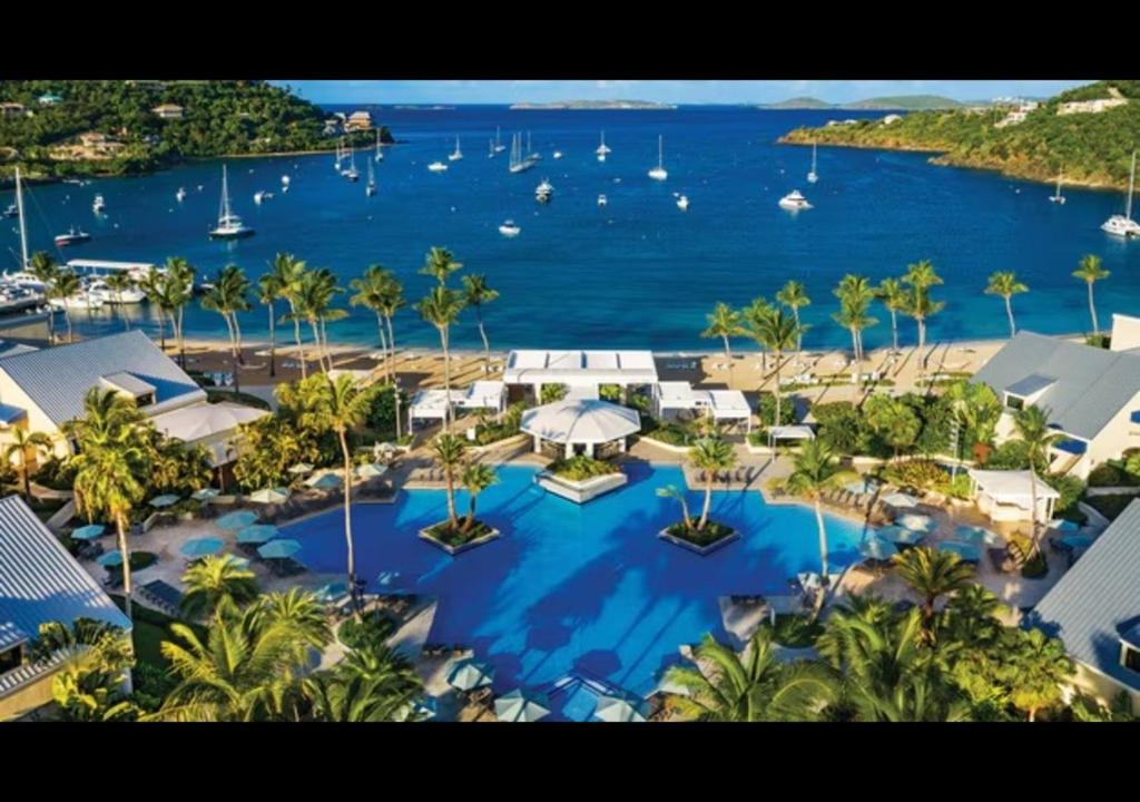 an aerial view of a resort with a large swimming pool at Beach fun with the family in this resort 3BD with onsite activities pool, kids room, and more in Cruz Bay