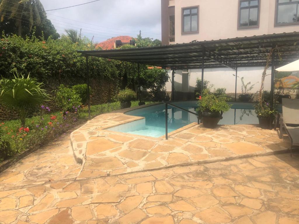 蒙巴萨Lusigi Luxe villas的后院的游泳池,带凉棚