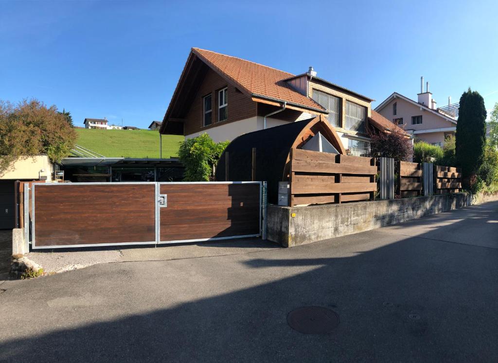 a wooden fence in front of a house at Grosse Ferienwohnung ideal für Gruppen, nähe Thun und Interlaken in Steffisburg
