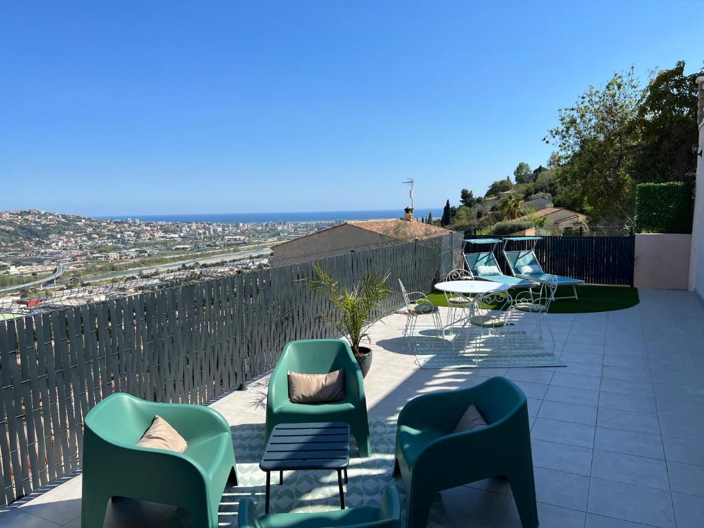 d'une terrasse avec des chaises et des tables et une vue sur la ville. dans l'établissement Bas de Villa 2P, Grande Terrasse, Vue mer, Plage à 15mn, à Saint-Laurent-du-Var