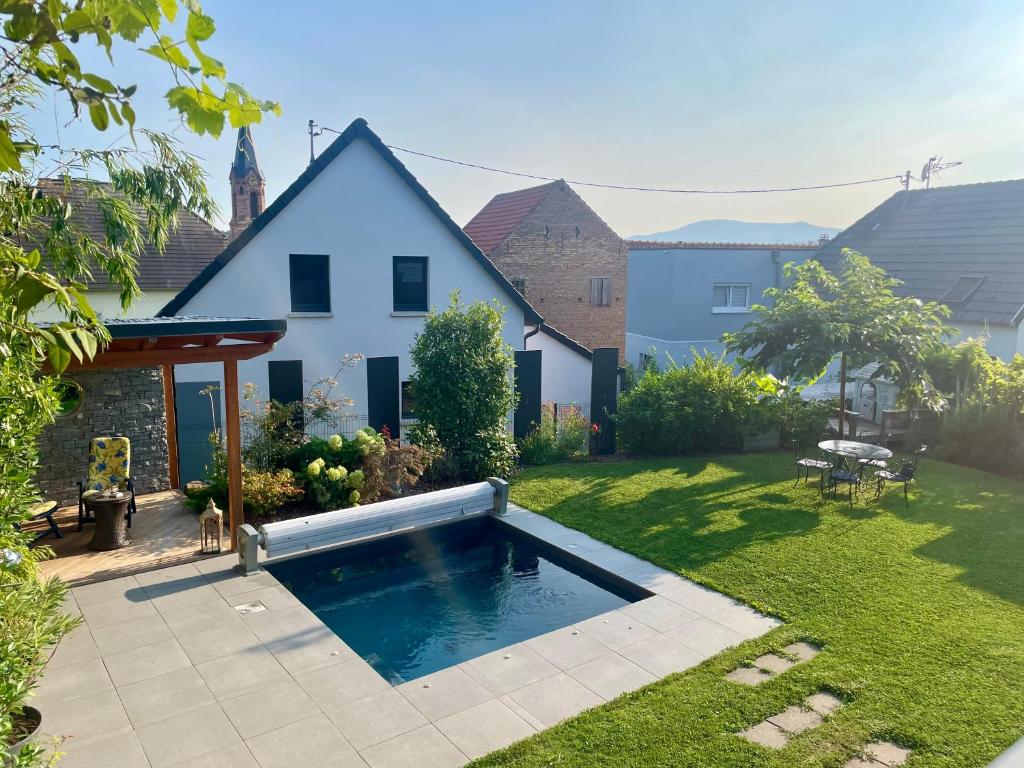 a swimming pool in the yard of a house at Chez L en Alsace - Maison avec jardin et piscine spa proche d'Obernai in Griesheim-près-Molsheim
