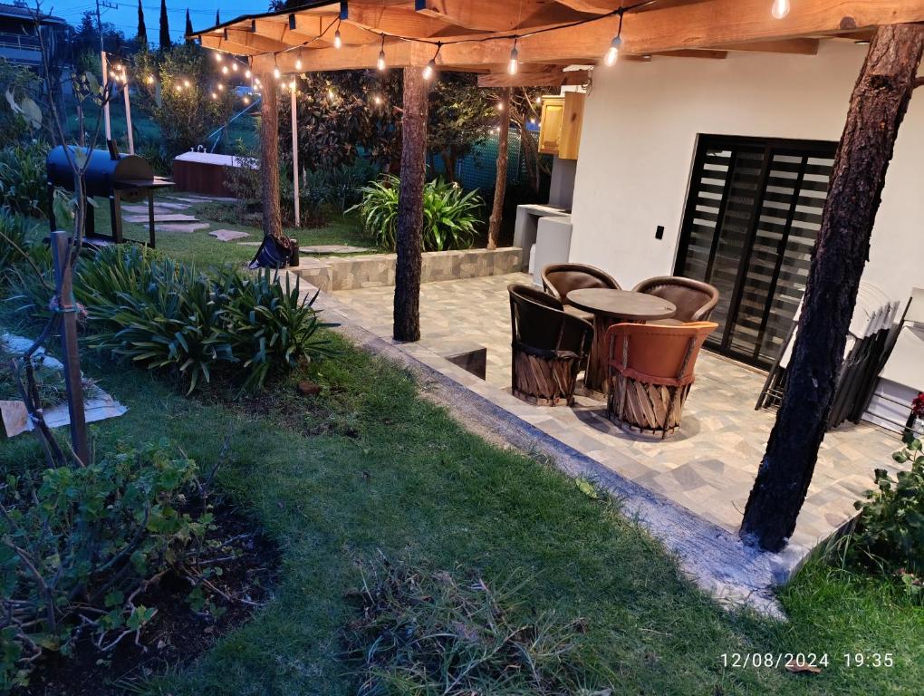 マサミトラにあるCabaña la Bonitaのパティオ(パーゴラの下にテーブルと椅子付)