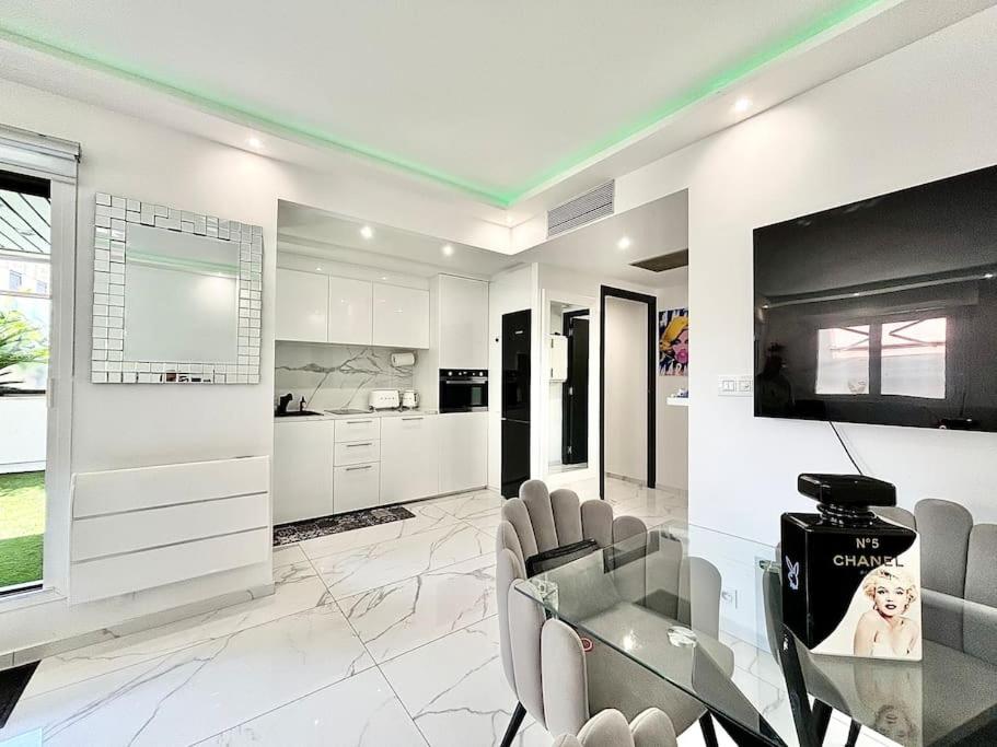 une cuisine blanche avec une table et des chaises en verre dans l'établissement Gray D'Albion -2A8- 1 Chambre, à Cannes