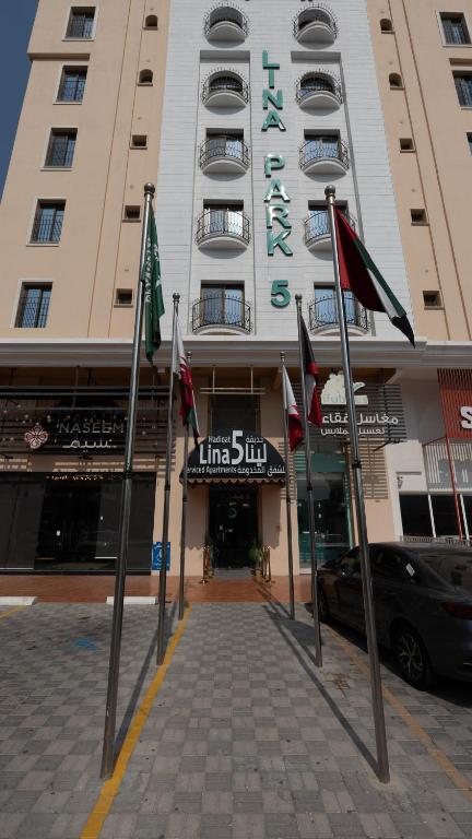 a large building with flags in front of it at Hadiqat Lina Serviced Apartments Al Khobar in Al Khobar